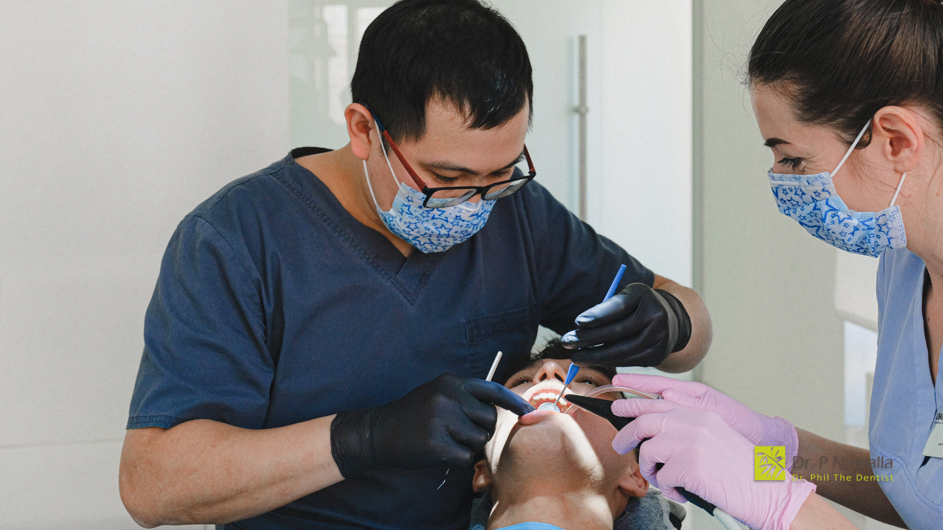 A dentist is examining a patient 's teeth in a dental office.