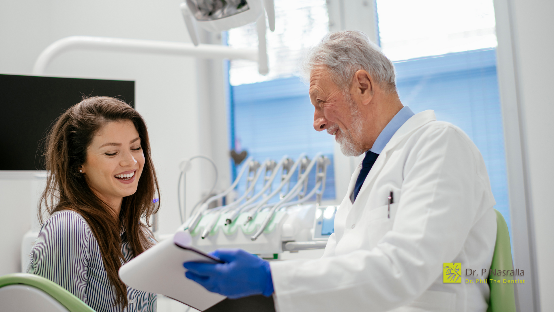 A dentist is talking to a patient in a dental office.