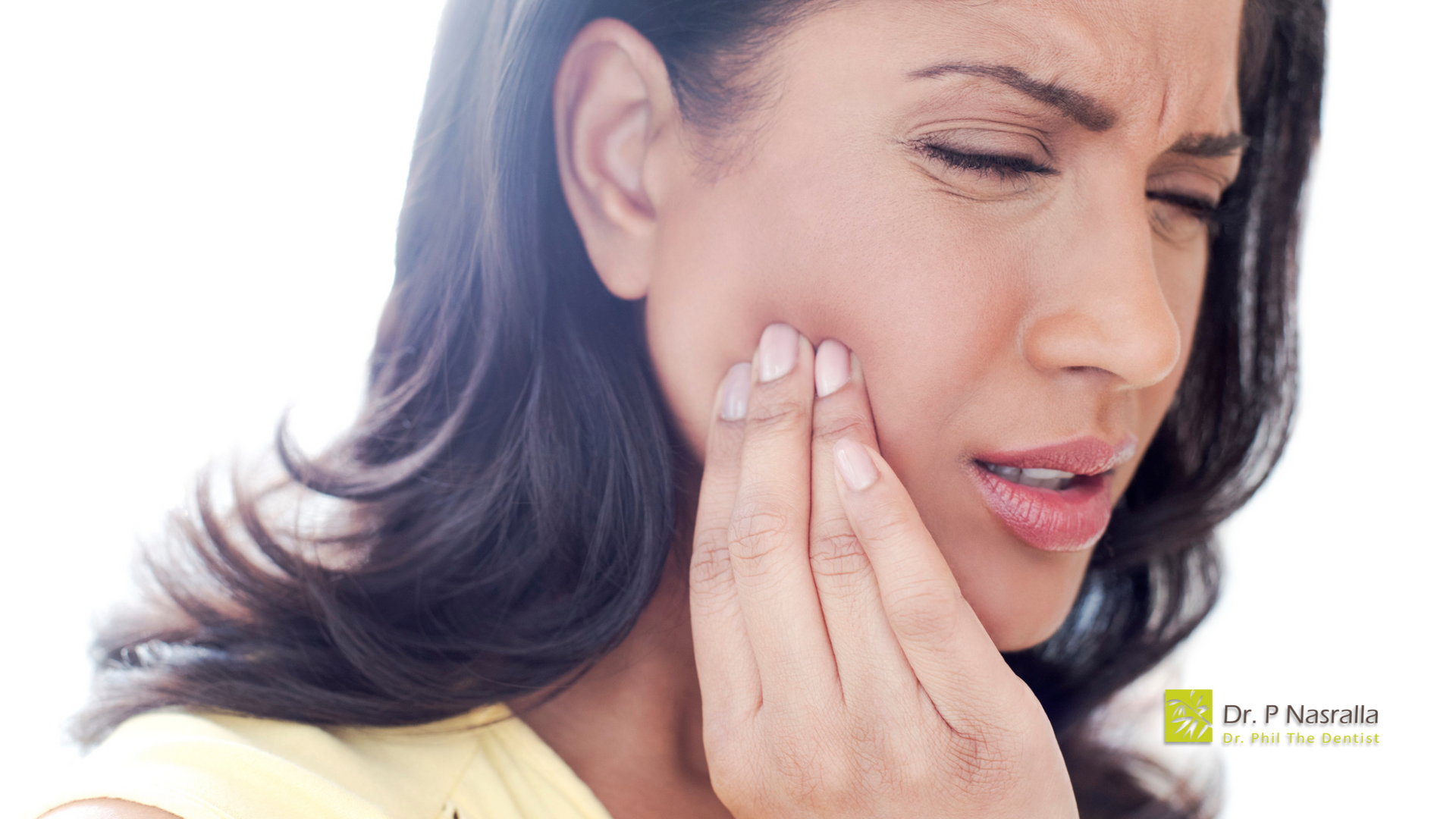 A woman is holding her face in pain because of a toothache.