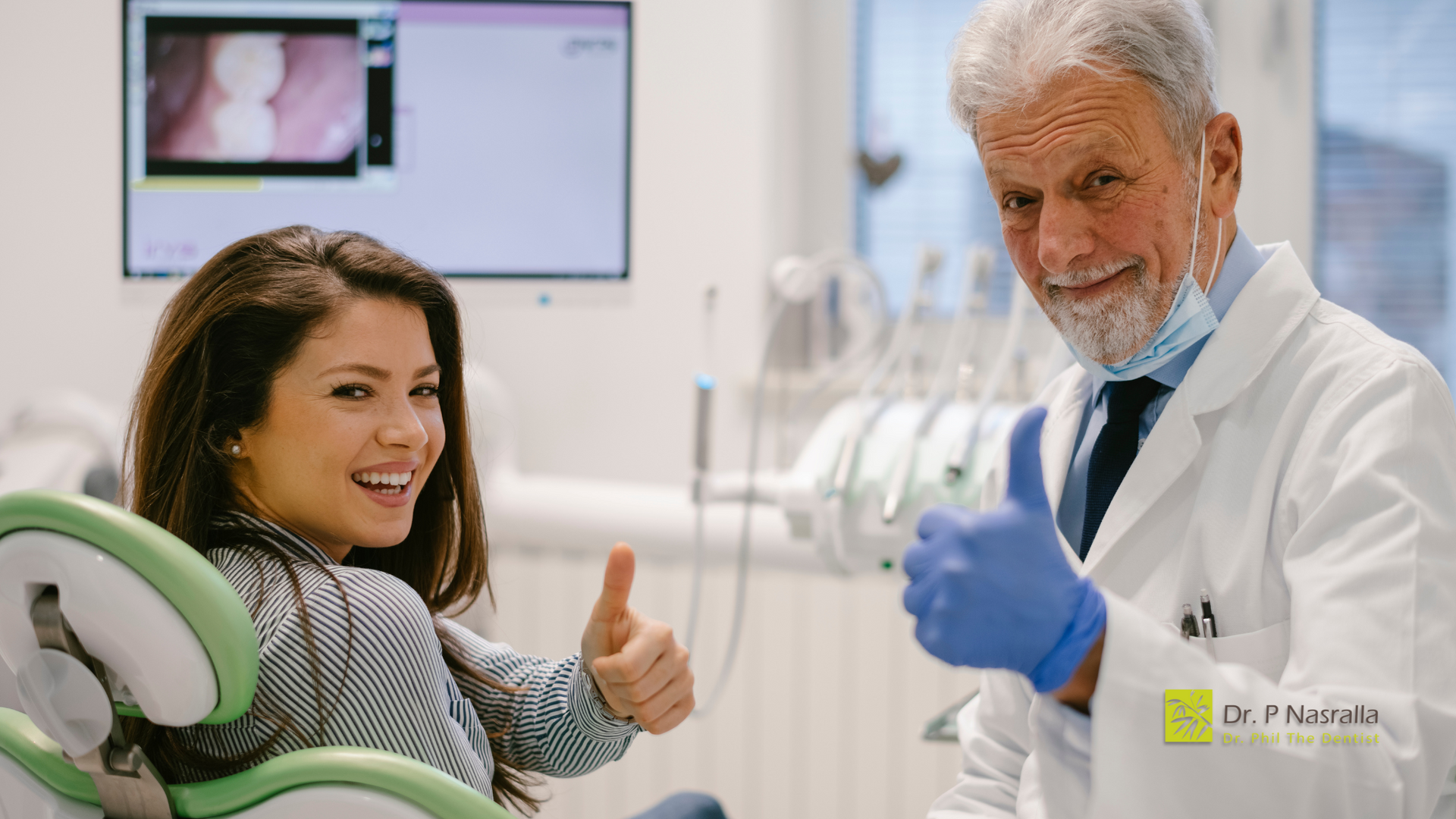 A dentist is giving a thumbs up to a patient in a dental chair.