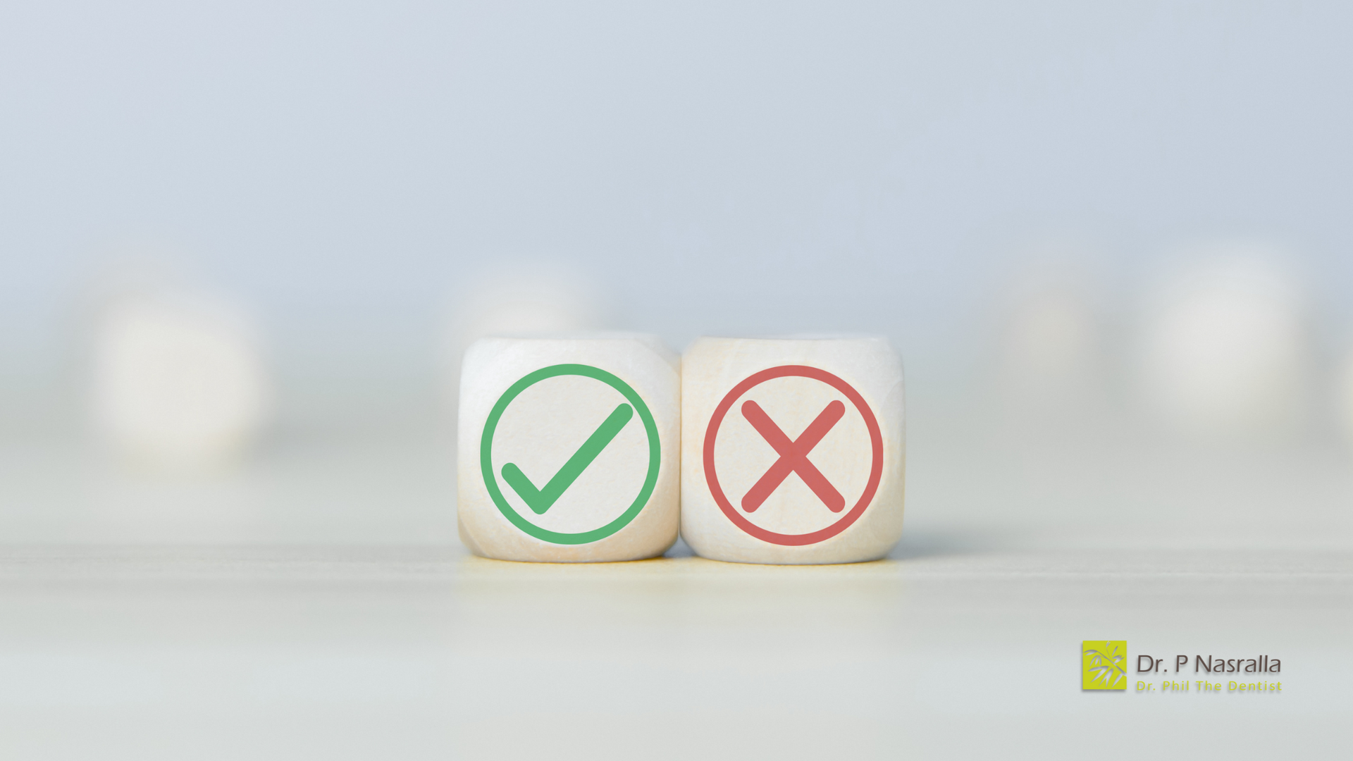 Two dice with a check mark and an x on them are sitting on a table.