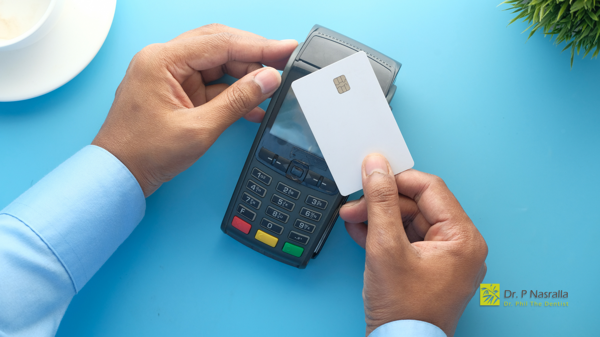 A person is holding a credit card in front of a credit card machine.