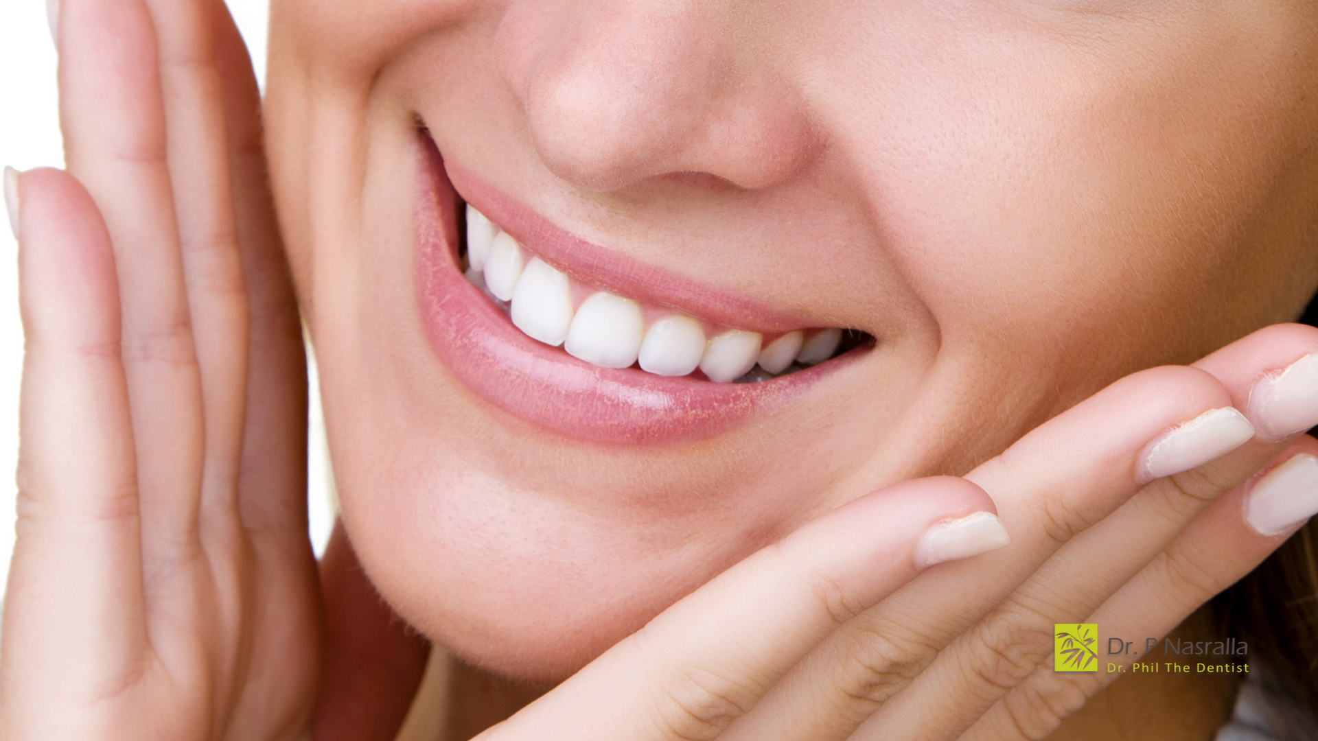 Woman smiling, showing white teeth, hands framing face.