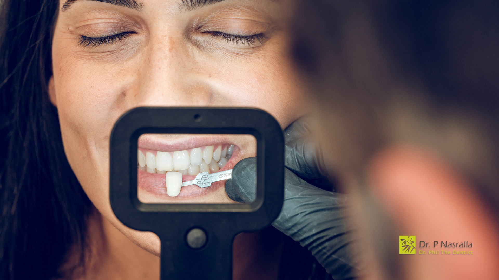 A woman is looking at her teeth through a magnifying glass.