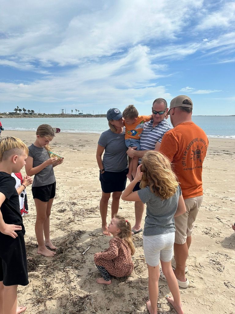 A group of people are standing on a beach.