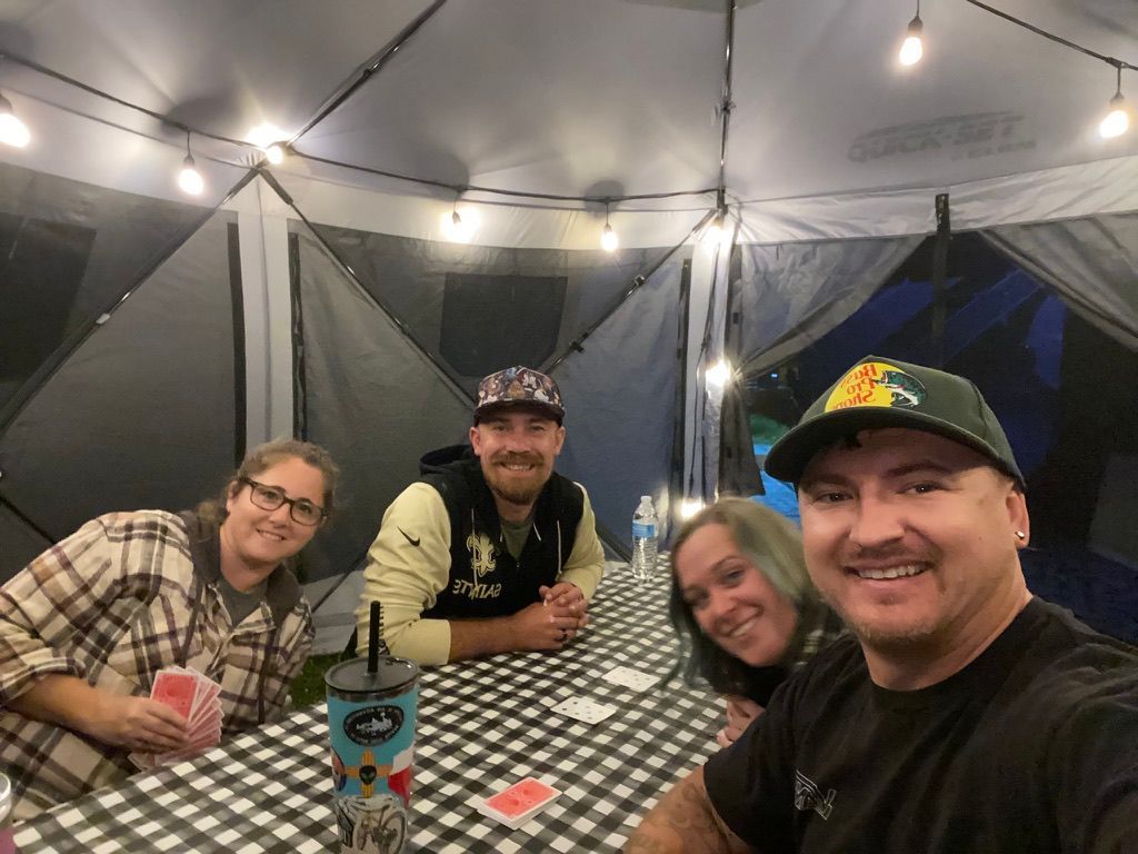 A group of people are sitting at a table under a tent.