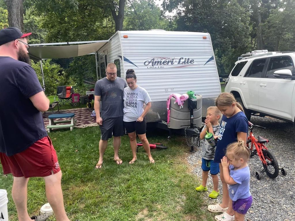 A group of people are standing in front of a trailer.
