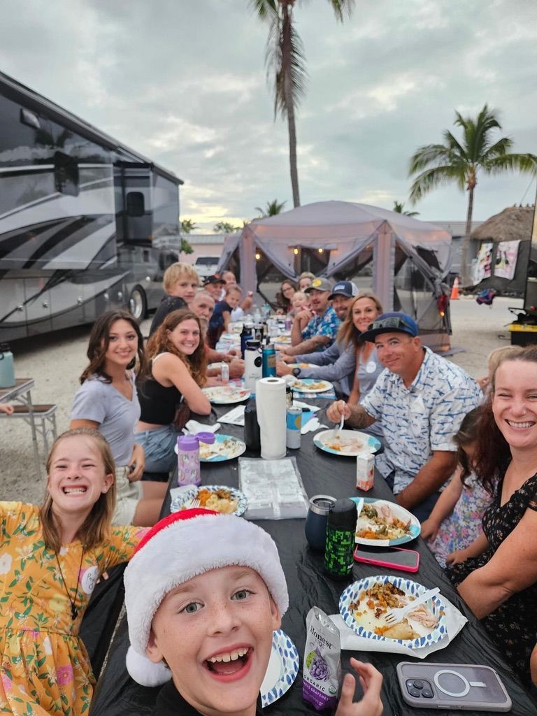 A group of people are sitting at a table with plates of food.
