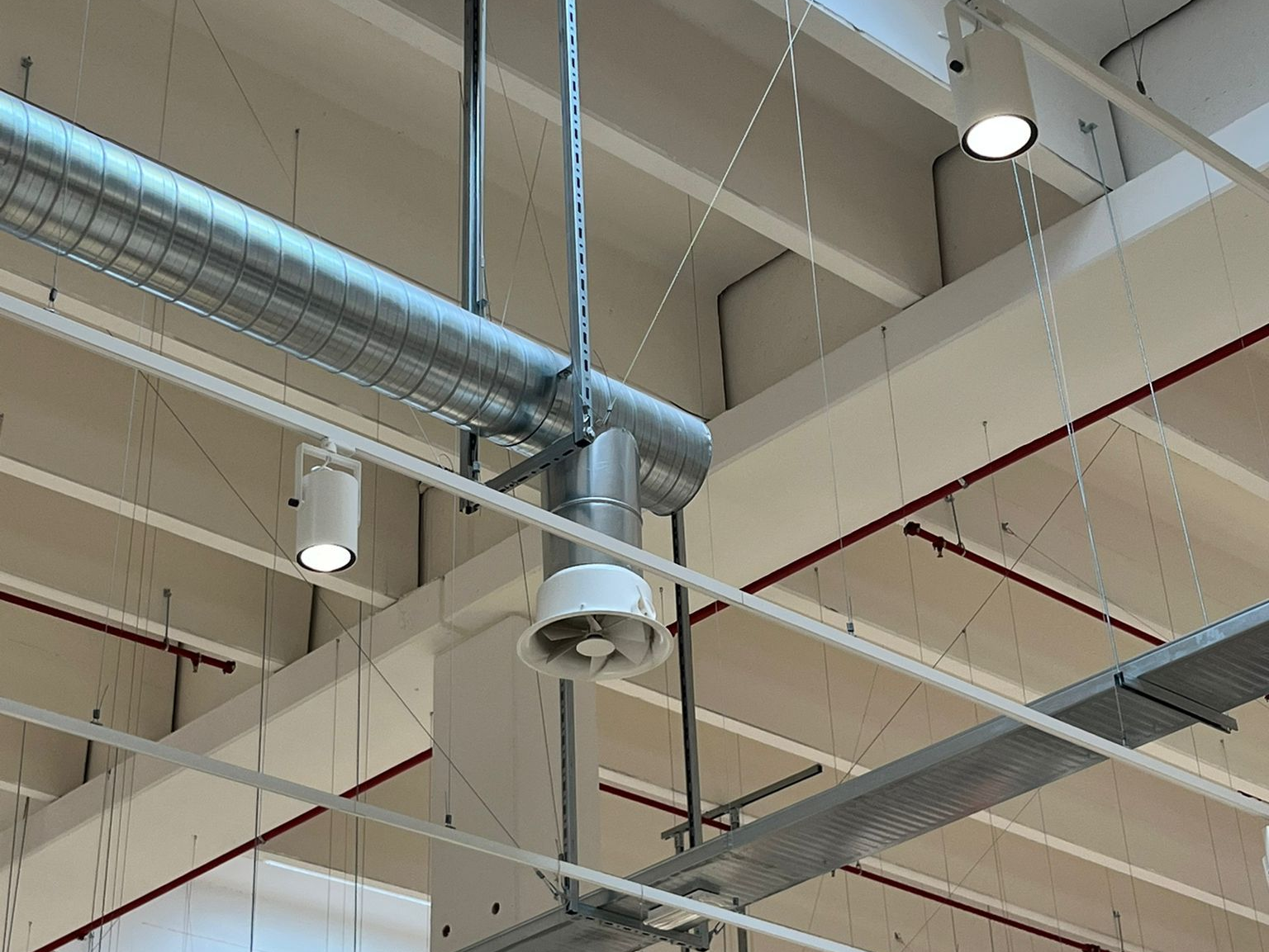 Tecnico con casco e guanti al lavoro sui macchinari.