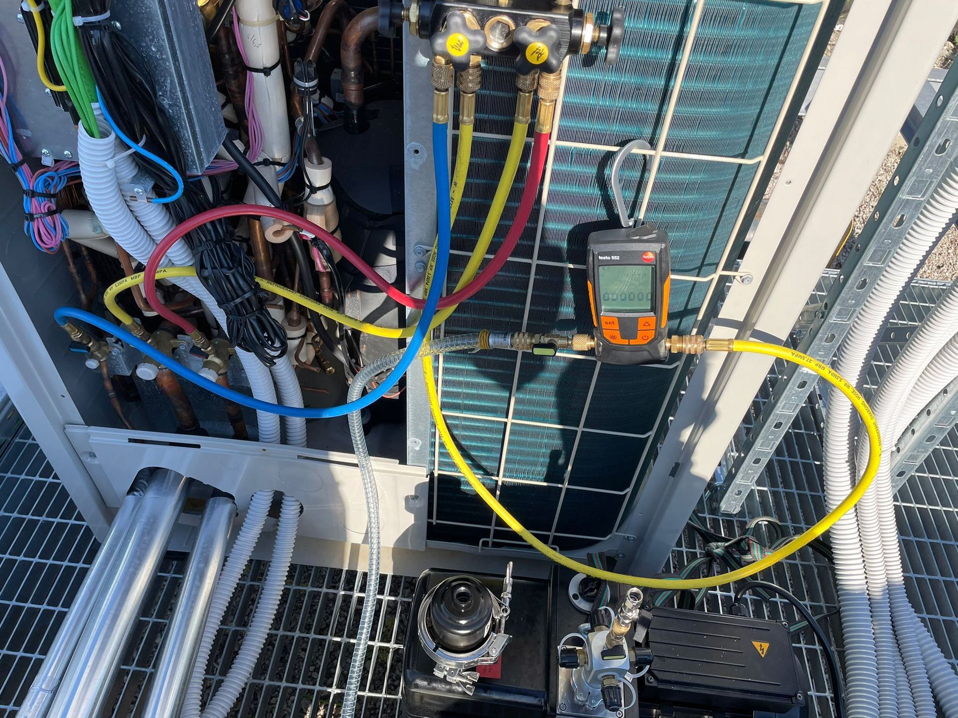 Tecnico HVAC che utilizza i misuratori su un'unità di condizionamento dell'aria