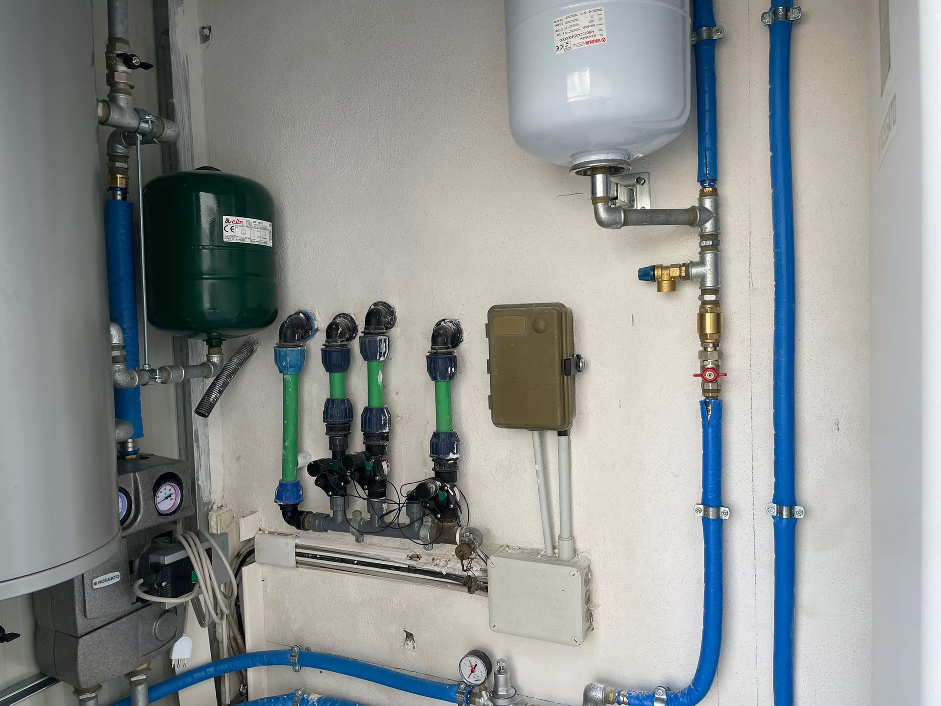 Stanza vuota in costruzione con pareti bianche, infissi a vista sul soffitto e grandi finestre.