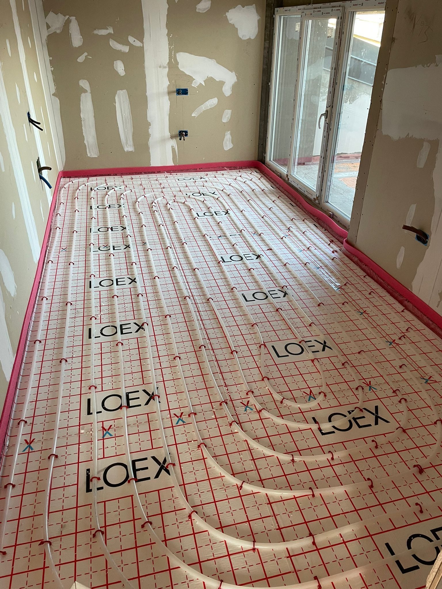 Stanza in costruzione con impianto di riscaldamento a pavimento radiante installato.