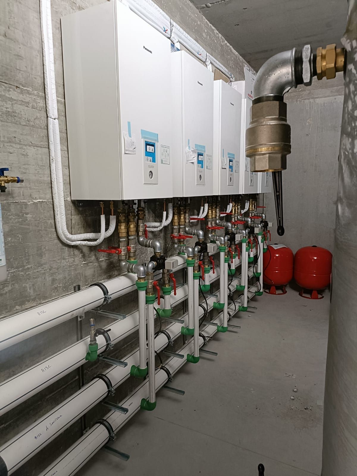 Tubi con isolamento e raccordi blu e rossi. Installazione a parete.