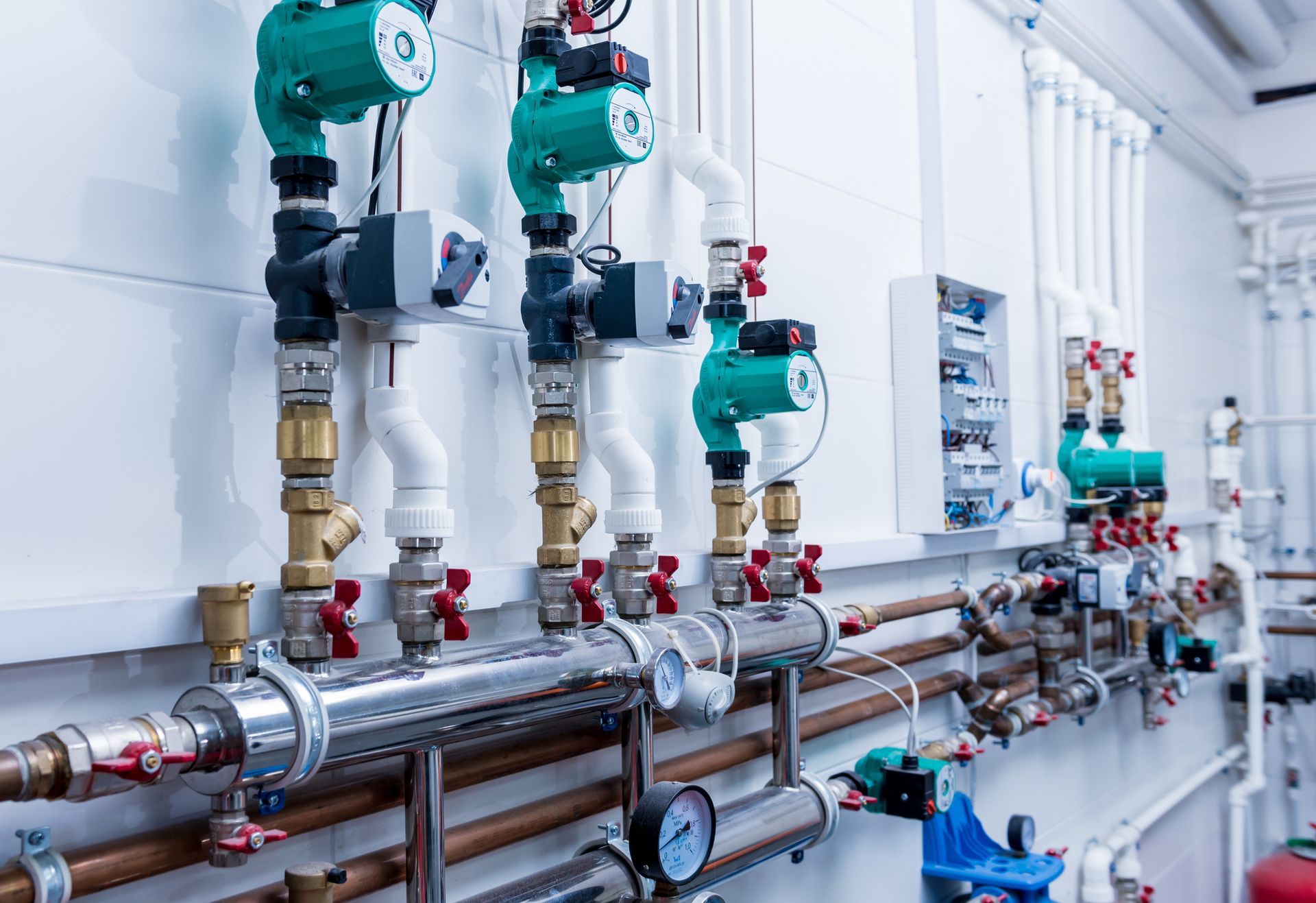 Complesso sistema idraulico industriale con tubi, valvole e pompe; per lo più bianco e color rame, per interni.