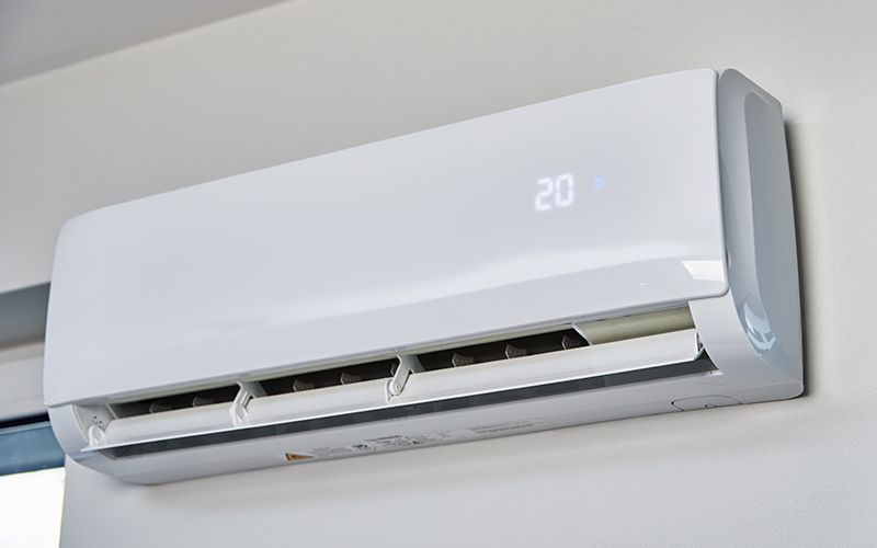 Unità di condizionamento dell'aria montata sulla facciata esterna di un edificio grigio.