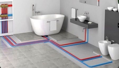 Primo piano di macchinari industriali: componenti blu, manometri e tubi flessibili.