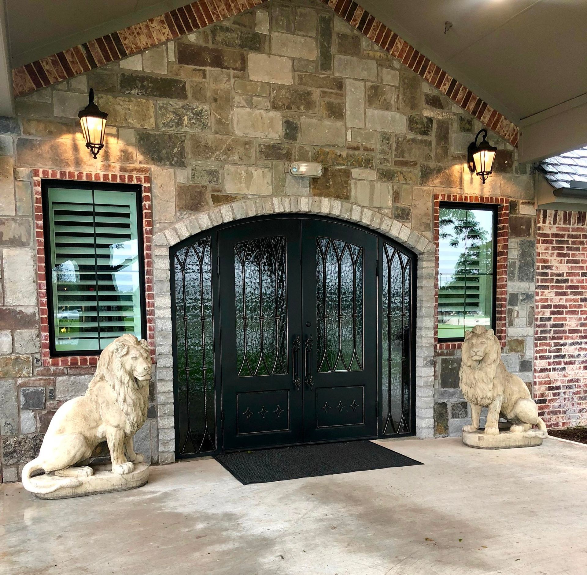 Two statues of lions are in front of a brick building