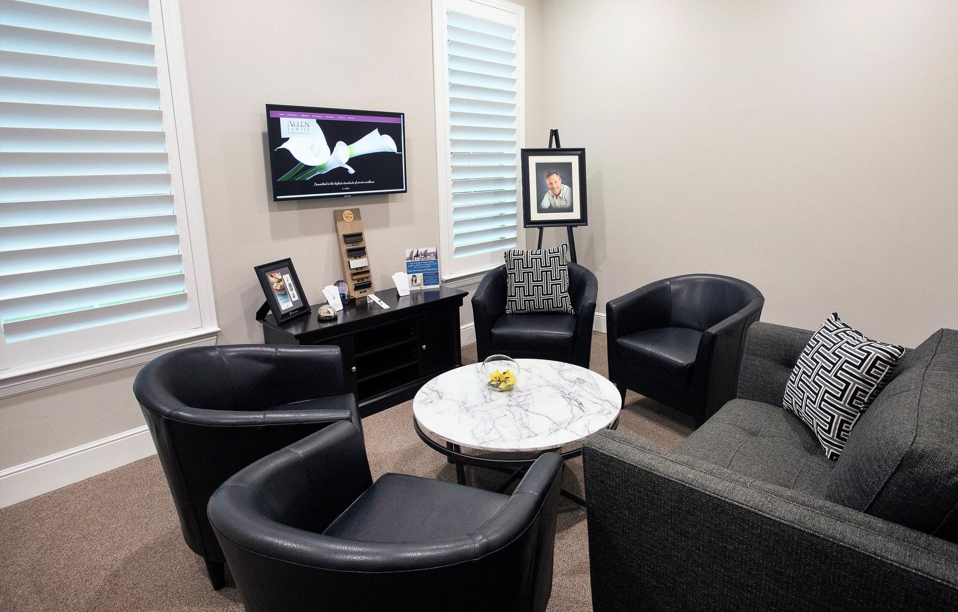 A living room with a couch , chairs , a table and a flat screen tv.
