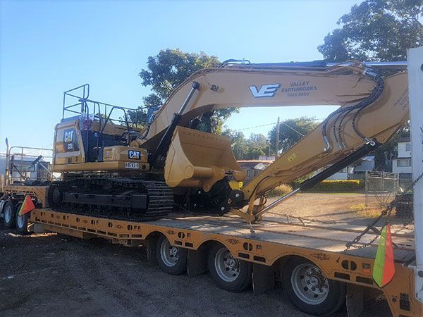 A large excavator is sitting on top of a trailer.