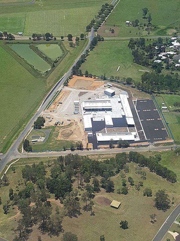 An aerial view of a large building in the middle of a field