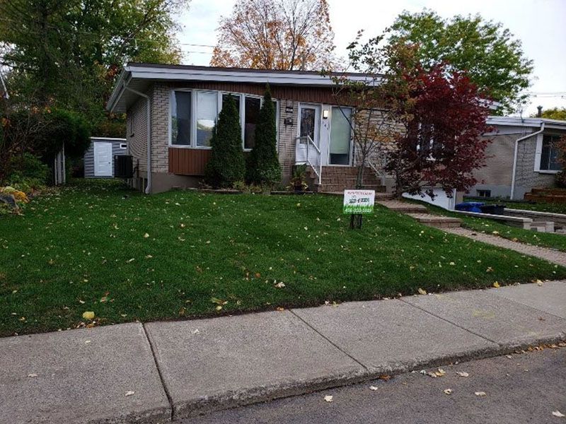 Une maison avec une pancarte à vendre devant elle