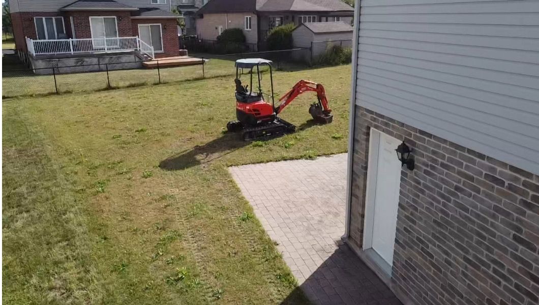 Une vue aérienne d'une maison avec une petite excavatrice dans la cour.