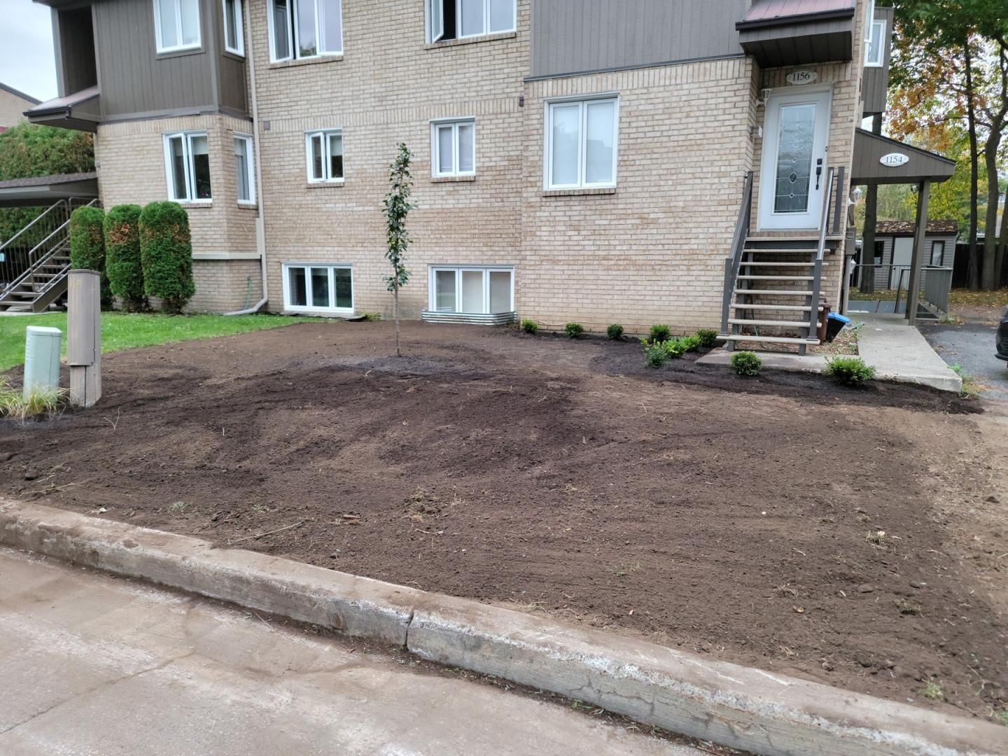 Une maison avec beaucoup de terre devant.