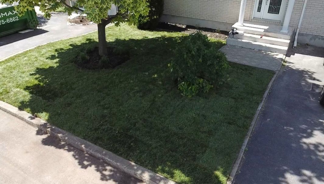 Une vue aérienne d’une pelouse verdoyante devant une maison.