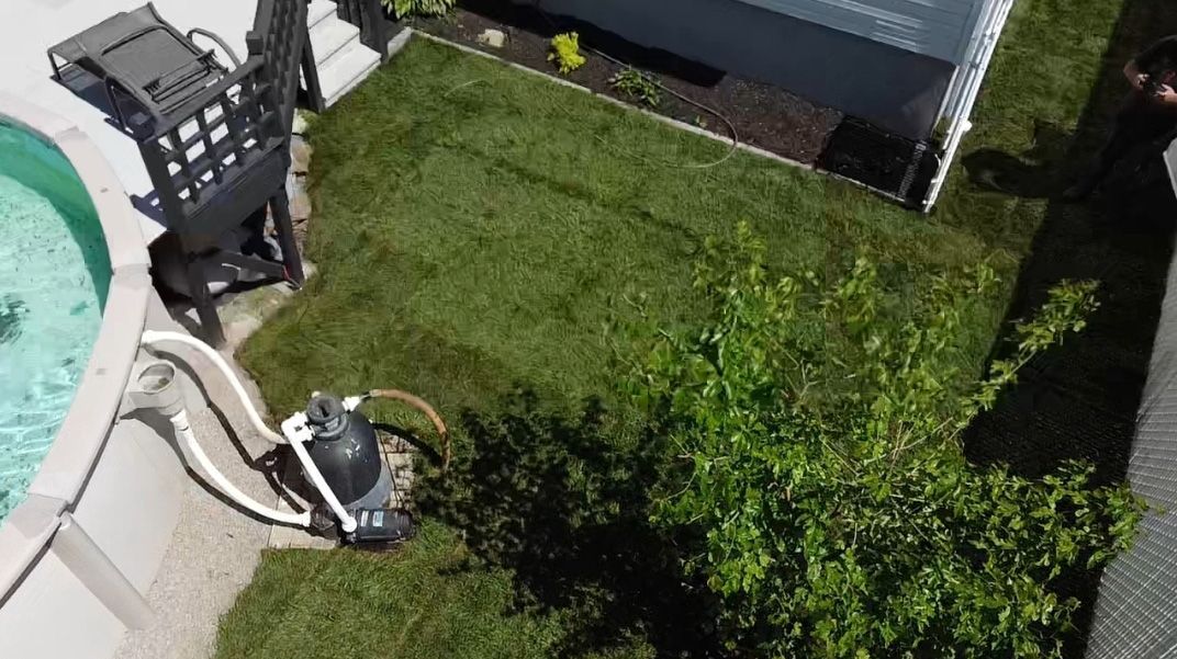 Une vue aérienne d’une cour avec une piscine et un grill.