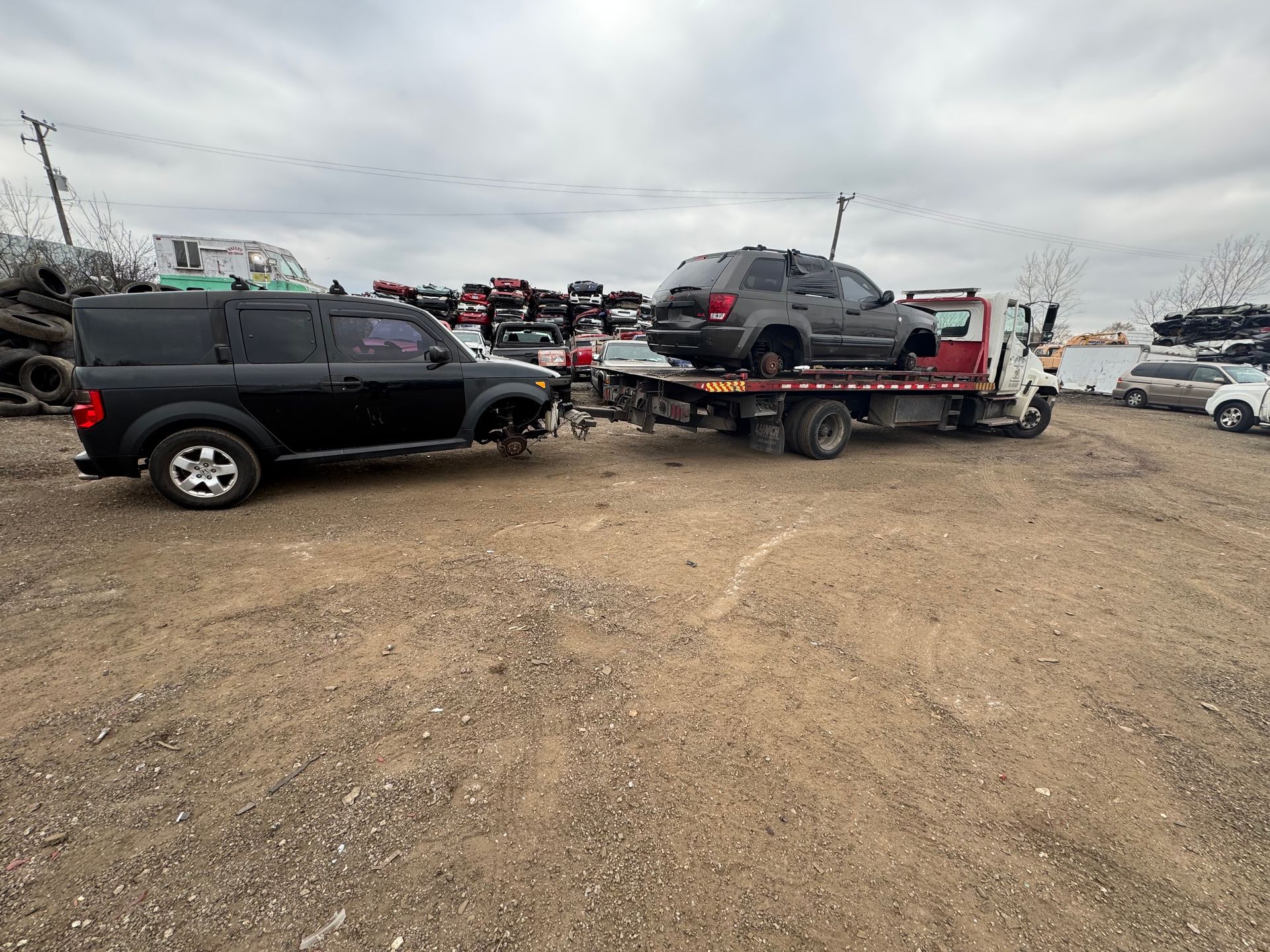 A red car is being lifted into the air by a crane.