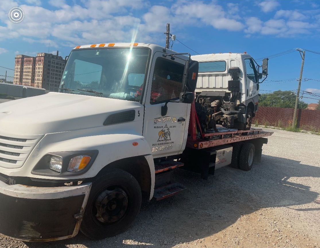 A man is giving a thumbs up in front of a tow truck.