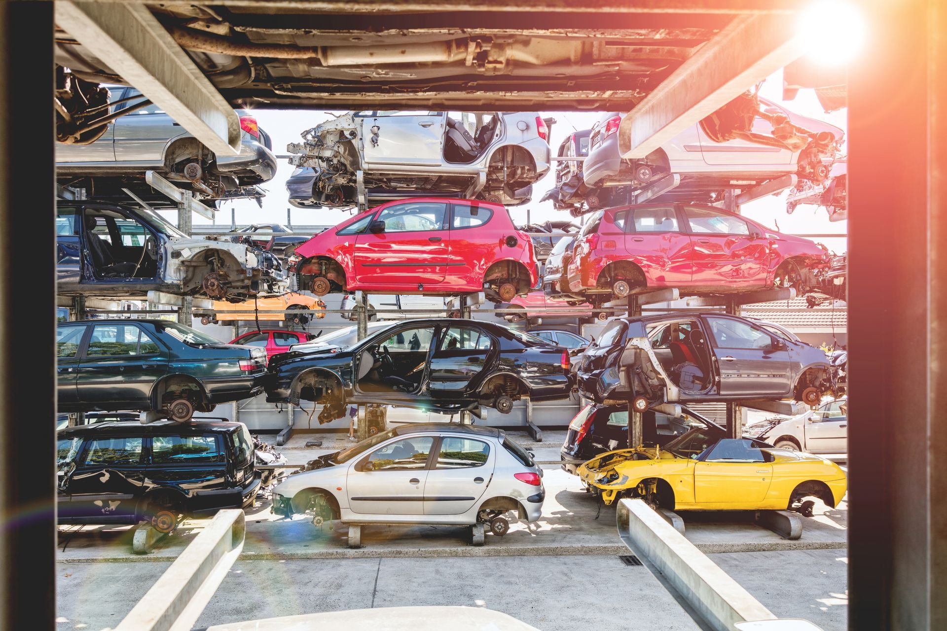 A bunch of cars are stacked on top of each other in a parking lot.