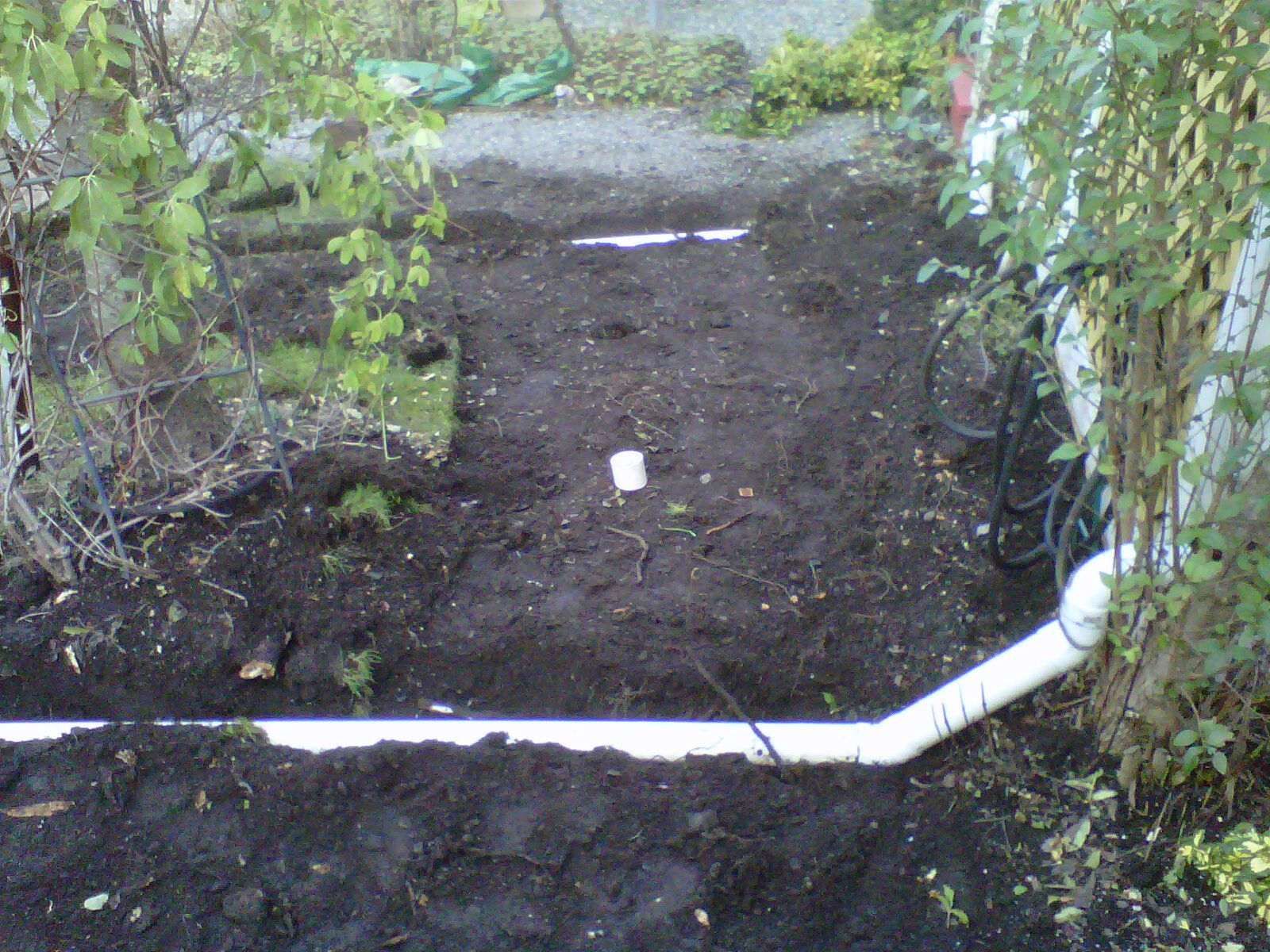 PVC drain pipe being installed in garden lawn