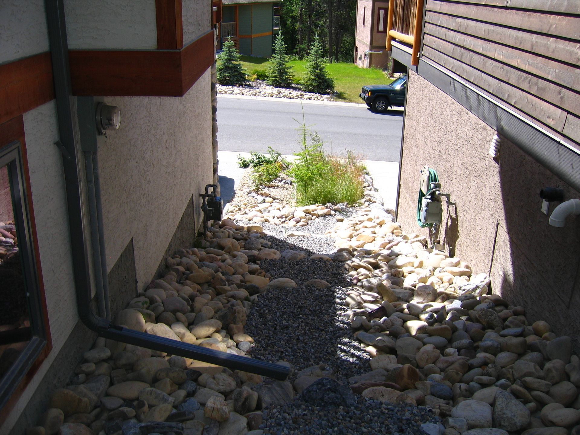 Another view of sloping drain rock drain system between two houses