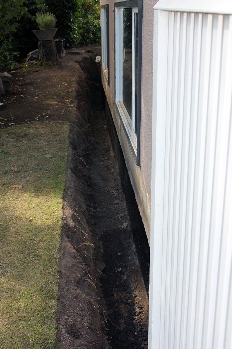 A trench around perimeter of home to access foundation for waterproofing spray