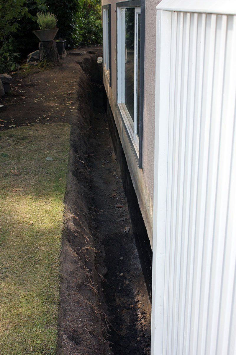 A trench around perimeter of home for foundation waterproofing to be serviced
