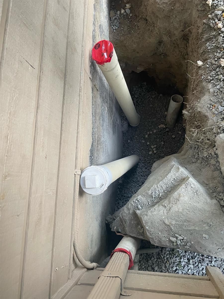 Looking into a trench where new drain pipes are being installed for a residential Saanich home