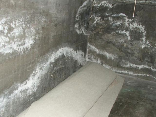 Water-damaged basement concrete wall before crack injection repair