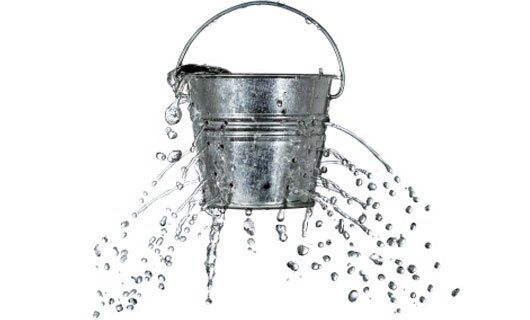 An image of water dripping out of holes in a bucket to illustrate the negative effects of an improperly installed rainwater harvesting system
