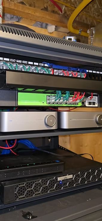 A rack of electronic equipment with patch panels, amplifiers, and a power supply.