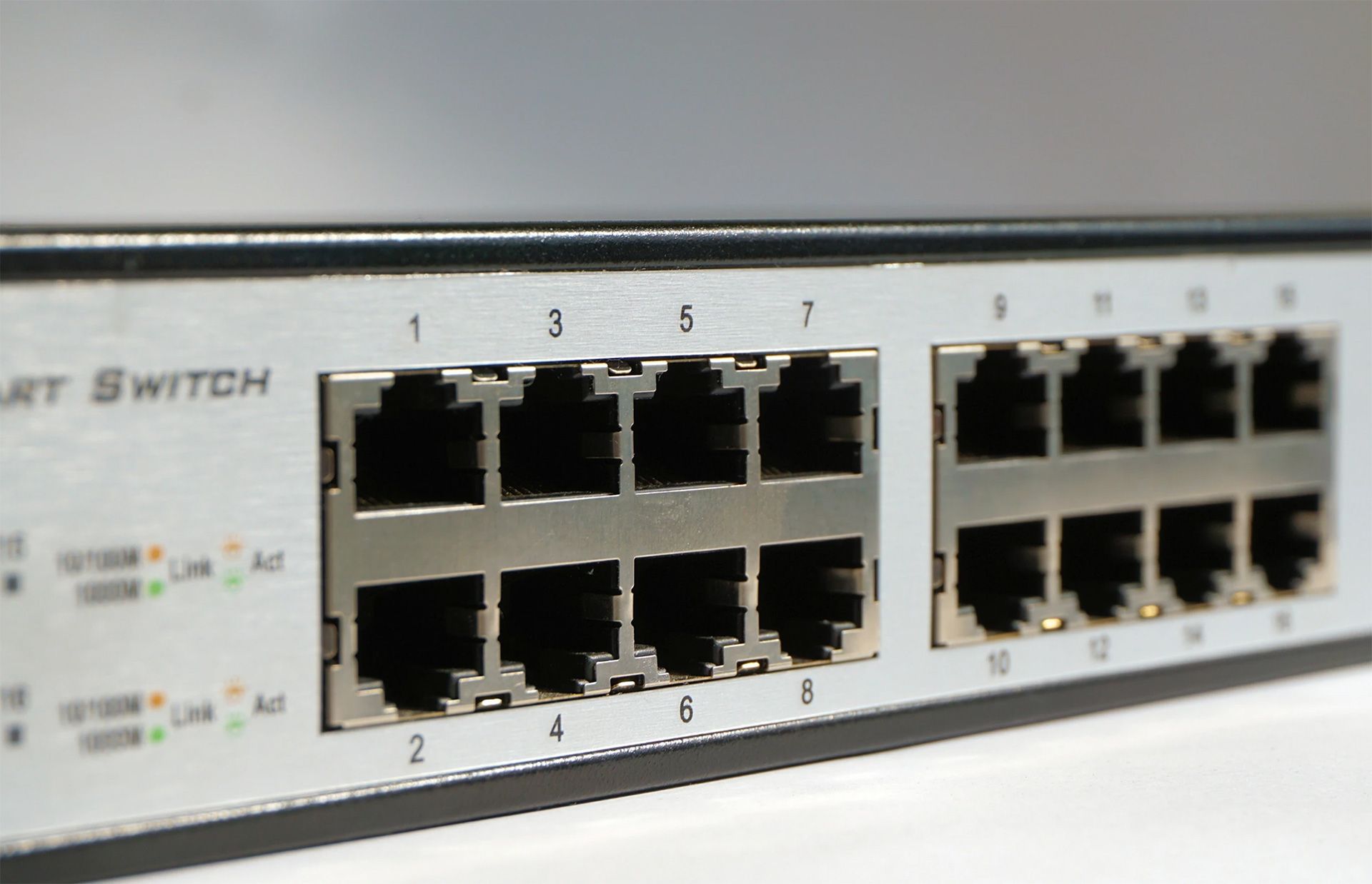 Close-up of a silver network switch with numbered Ethernet ports. Some ports have indicator lights.