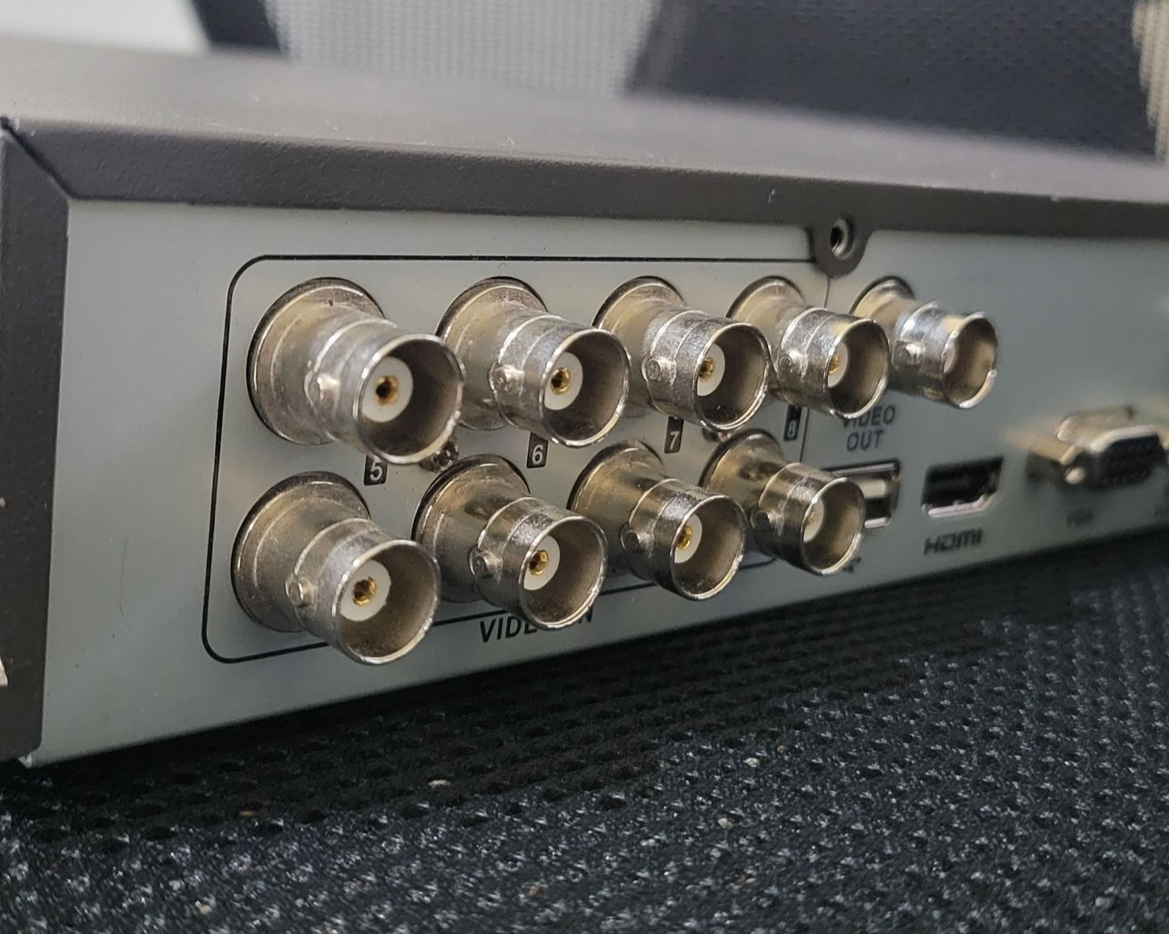 Close-up of security camera DVR rear panel with BNC video input ports labeled A, B, and video out.