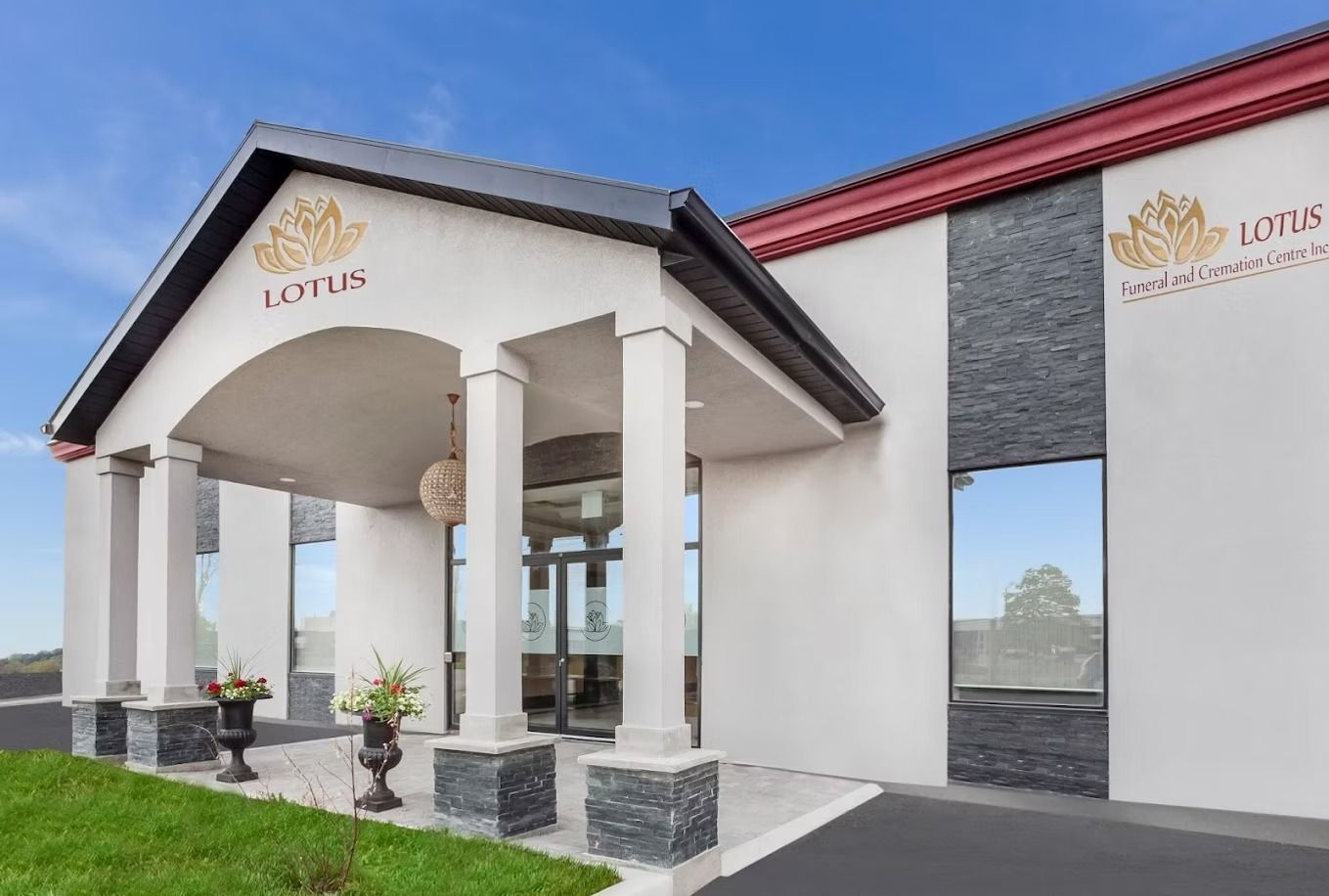 Entrance of Lotus Funeral and Cremation Centre; white building with gold logo and columns; blue sky.