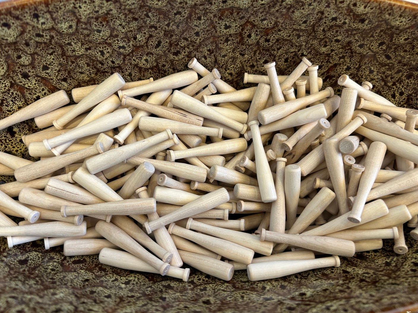 Mini baseball bats given as mementos, celebrating the spirit of the young player and the baseball-themed memorial.