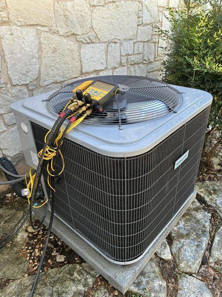 Air conditioning unit with diagnostic equipment attached.