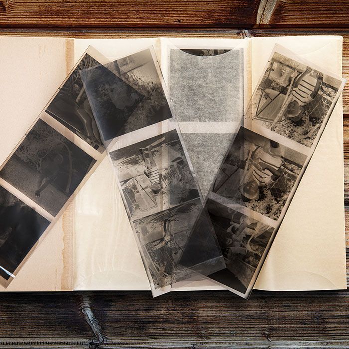 A book filled with black and white photographs on a wooden table.