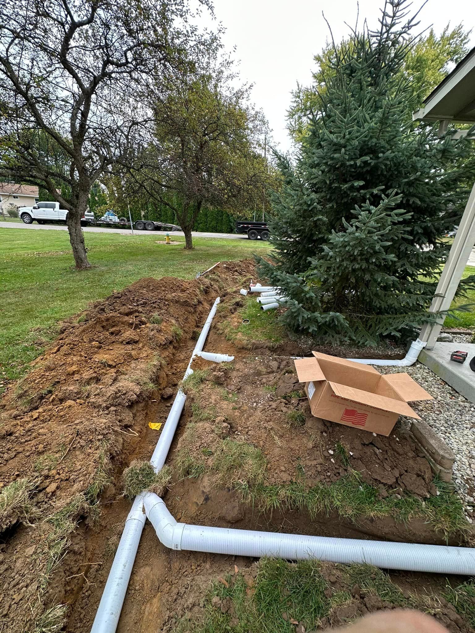 a box is sitting on the ground next to a drain pipe .