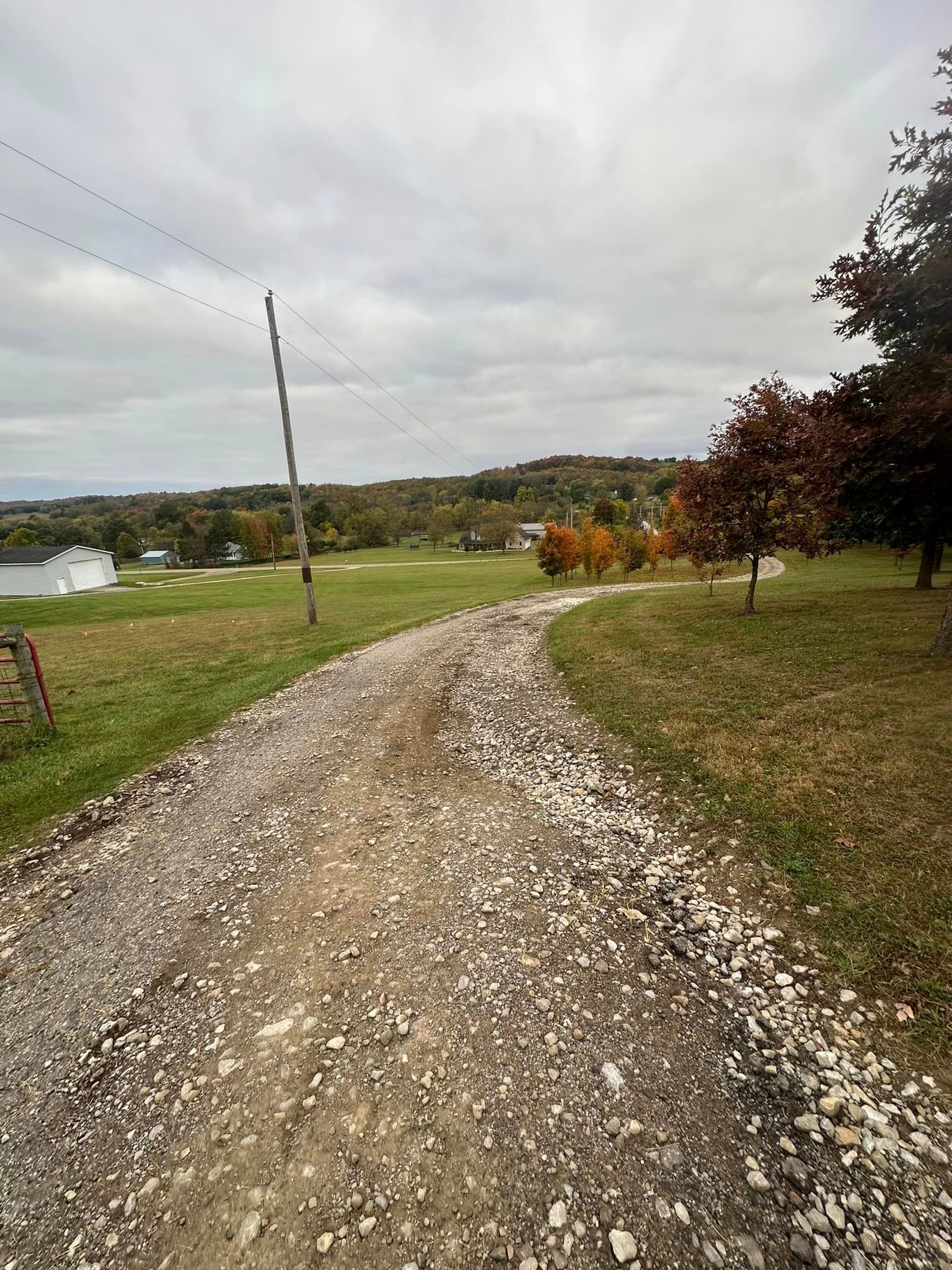 a gravel road going through a grassy field .