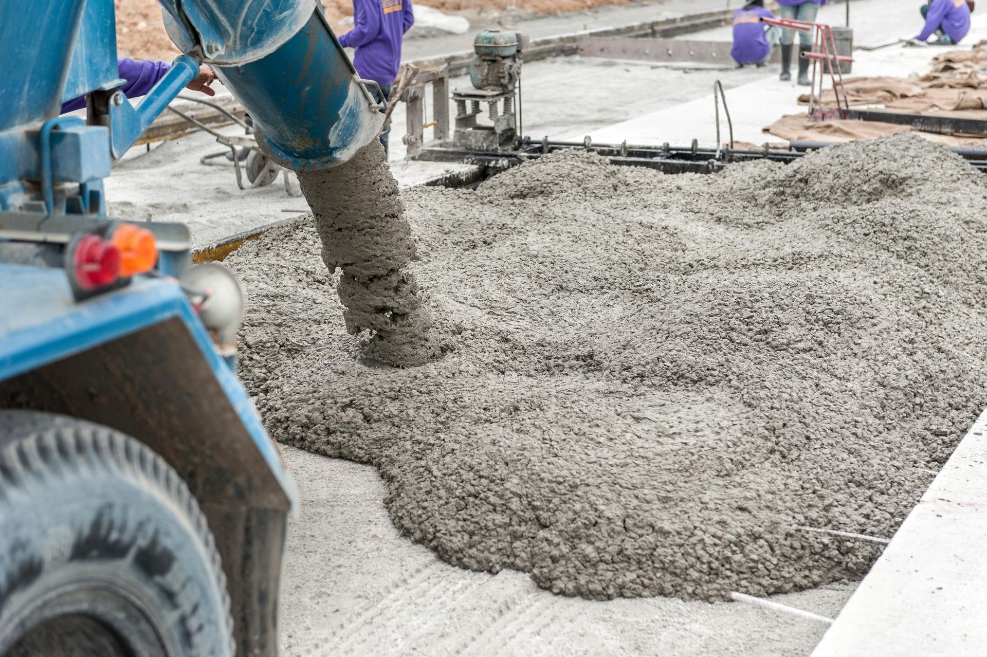 a truck is pouring concrete on a construction site .