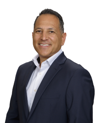 A man in a suit and white shirt is smiling for the camera.